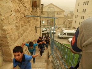 Schüler*innen auf der Treppe zur Cordoba Schule, gegenüber die Siedlung Beit Hadassah