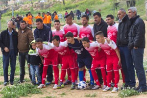 Die Mannschaft aus Susiya beim Gruppenbild, im Hintergrund in Orange die Spieler aus Um al Kheir