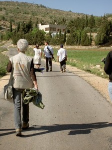 Eine Ökumenische Begleiterin beobachtet bewaffnete Siedler*innen auf dem Weg nach Yanoun