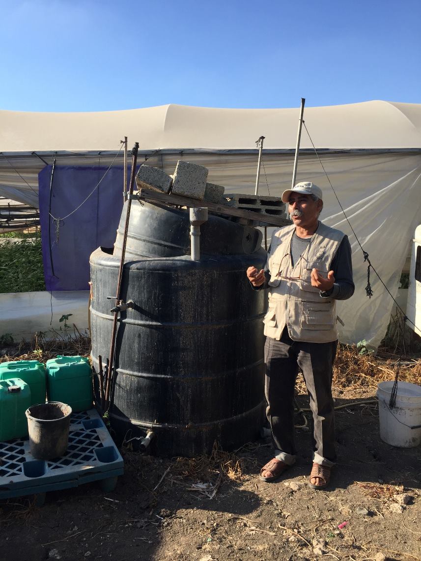 Organischer Farmer Fayez und der Tank mit seinem Spezialdünger, der „Suppe“ (Photo: EAPPI)