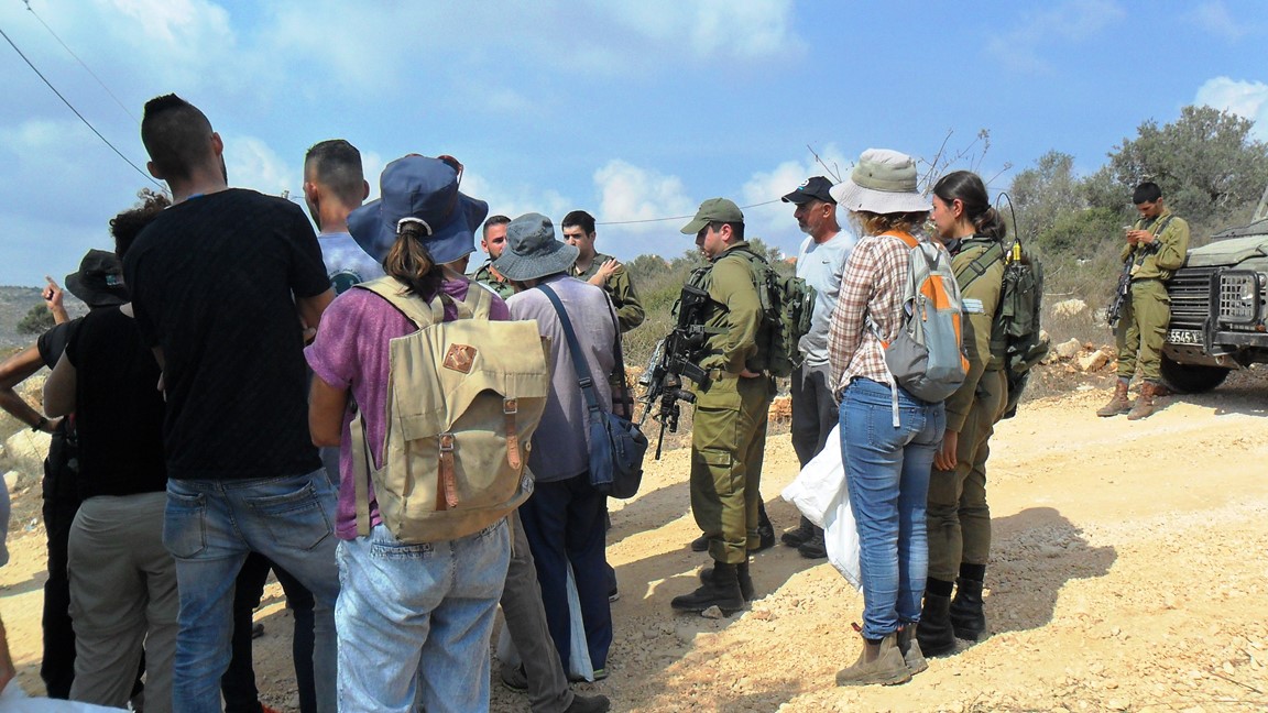 Bauern und freiwillige Helfer im Gespräch mit israelischen Soldaten in Haris, © EAPPI