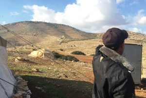 Aziz zeigt auf das verlassene Haus am Fuße des großen Hügel; dort finden immer wieder Militärübungen stattfinden; ©EAPPI