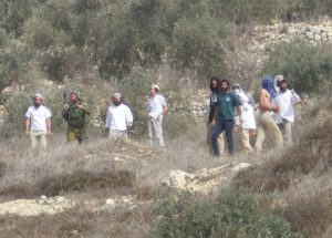 Siedler aus Yitzhar greifen Bauern in Burin mit Steinen an, ein Soldat steht dabei, schreitet aber nicht ein; © EAPPI