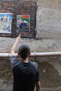 Mohammad und ein Solidaritätsplakat mit seinem Foto, das im Camp aufgehängt wurde. (Photo: EAPPI)