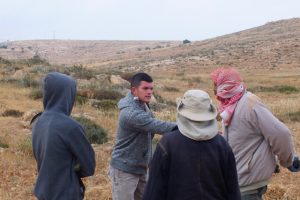 Ein Siedler vom Außenposten Nof Nesher (Mitte) konfrontiert die Farmer © EAPPI