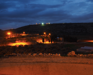 Foto aufgenommen in Upper Yanoun mit Blick auf den gegenüber liegenden Außenposten „Hill 777“ mit Fluchtlichtern; © EAPPI