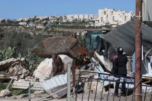 Bulldozer während der Hauszerstörung in Khirbet Khamis, im Hintergrund die Siedlung Gilo; ©Raed Abu Tarboush