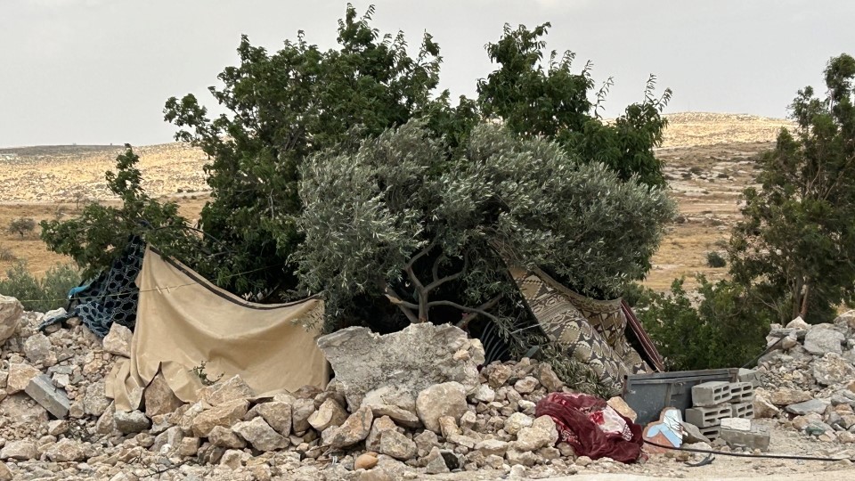Unter einem Baum und mit Decken und Teppichen versehen haben Bewohner:innen von Khallet Athaba einen Unterschlupf errichtet; © WCC-EAPPI/Nadja