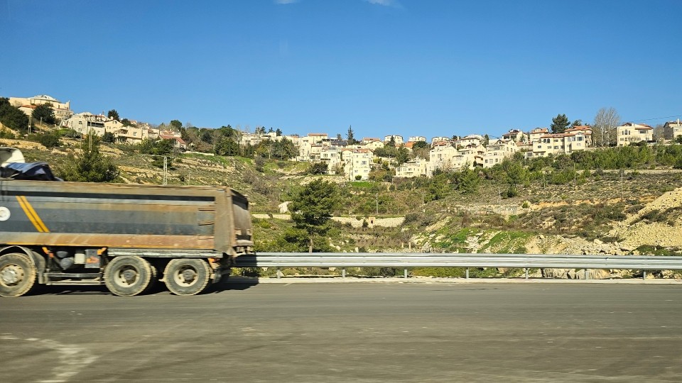 Baufahrzeug für den Straßenbau im Raum Bethlehem, dahinter eine der vielen völkerrechtswidrigen Siedlungen in der Region; © WCC-EAPPI/Lee